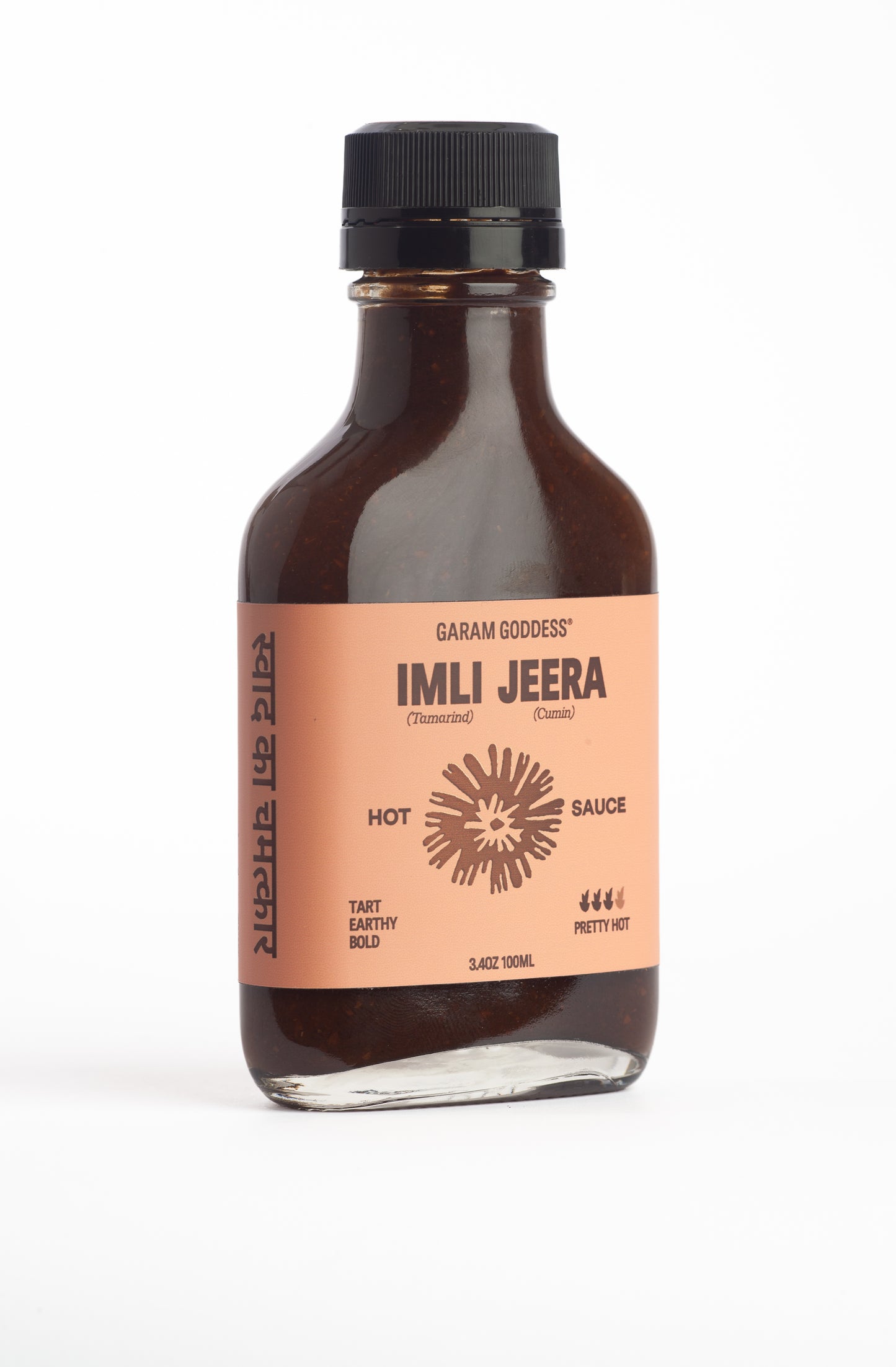Bottle of Imli Jeera hot sauce with a brown label on a white background